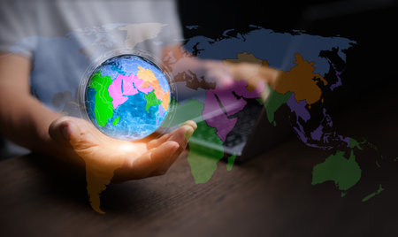 A businessman holding a digital globe with regional maps symbolizes regionalism, economic...