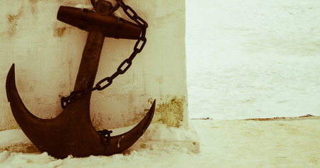 black anchor on a background of white snow retro photoの写真素材