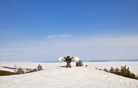 Snowboarder lies on the bench  Against the backdrop of beautiful mountain  landscape of winter  A sunny day の写真素材