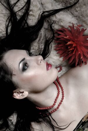 The beautiful girl the brunette lies on fur having stretched hair.の写真素材