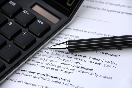 On a table the pen, the calculator, the contractの写真素材