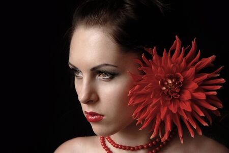 Portrait of the beautiful girl with a red big flowerの写真素材