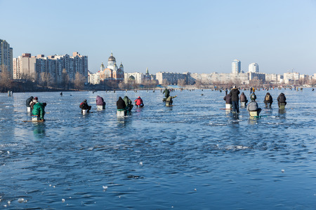 man on winter fishing, people on the ice of the frozen lake, fishermen, urban landscape,の写真素材