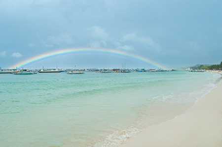 After the rain a rainbow is seen far from a sea pier,Rainbow over the pierの写真素材