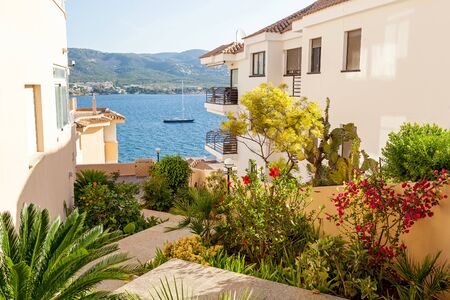 The winding street of the resort town, which offers a wonderful view of the sea and the mountains and around the riot of colors of various flowering plants.の写真素材