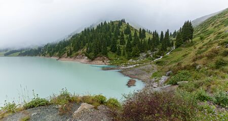thick white mist over the Big Almaty Lake, large natural reservoir of fresh waterの写真素材