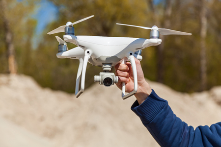 Ukraine, Kyiv 25 april 2017   A hand holds white quadcopter,quadcopter takes off video and photo of...