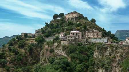 on the top of the hill among the green trees stands the ancientの写真素材