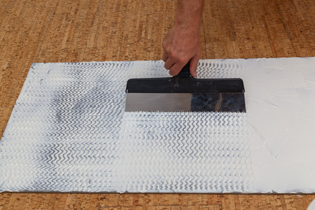 isolating panels for the economy of heat, building materials for repair of houses and apartments,imposition of glue a spatula on an isolating panelの写真素材