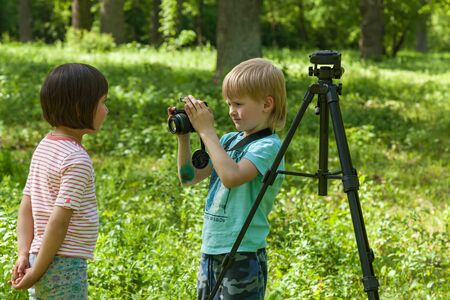 photo session for a little girl, children play a photographer and photo a modelの写真素材