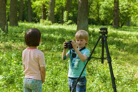 photo session for a little girl, children play a photographer and photo a modelの写真素材