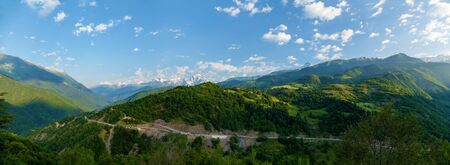 View of mountain peaks. Mountain road and mountains with cloudsの写真素材