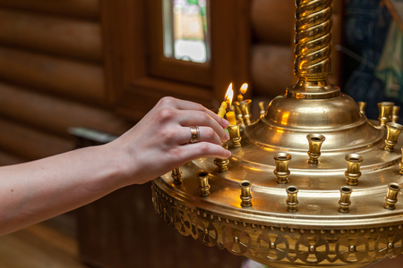 A woman in the church lights a candleの写真素材
