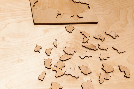 Wooden puzzles lie on a wooden tableの写真素材
