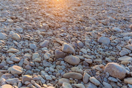 Top view background of rounded pebbles at the beach. Pebbles in the sun.journey to Georgiaの写真素材