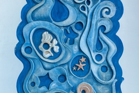 Gypsum decorative ornament of blue color with marine inhabitants on a white wall.the sea and the fish on the wallの写真素材