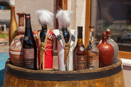 Georgia Tbilisi June 17, 2017: Bottles of Georgian alcoholic beverages standing on a wooden barrel. travels around Georgiaのeditorial素材