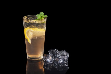 alcohol cocktail with lemon and mint on a black backgroundの写真素材