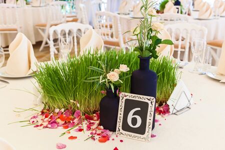 decor green grass and rose petals for the wedding table. Elegant wedding reception area, ready for guests and the bridal party.Table for guests in the wedding hall.の写真素材