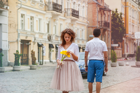 A happy girl walks around the city with a bouquet of yellow Gerber flowersの写真素材
