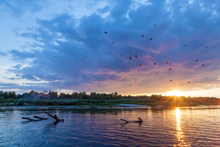 Countryside landscape of a beautiful sunset and clouds over the riverの写真素材