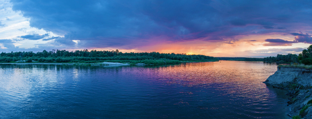 Countryside landscape of a beautiful sunset and clouds over the riverの写真素材