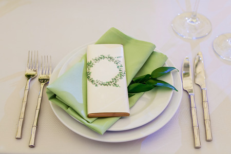 Design and decor decoration of the wedding celebration with white roses, green leaves, candles and...