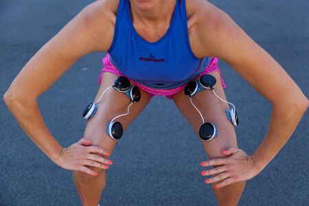 Kiev Ukraine September 21, 2018: Compex pacemaker for fitness. Install electrostimulator on the muscles of the legs. Fitness training with an electrostimulator.のeditorial素材