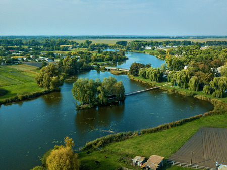 Small house one the island. Landscape with bridge to the house on lake. Old wooden fisherman's and...