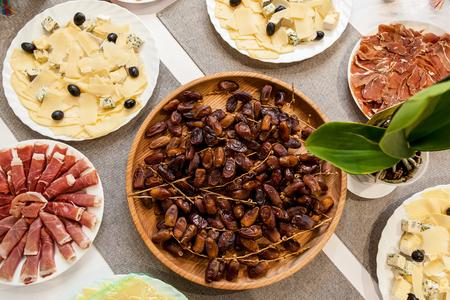 Various appetizers of cheese, meat and dates for a buffetの写真素材