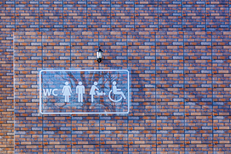 Glass public toilet sign with a disabled access symbol and woman with babyの写真素材