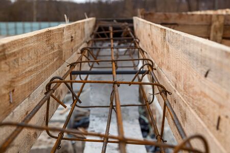 Metal structures for concrete structures. Construction site, tools, wheel barrow, sand and bricks at...