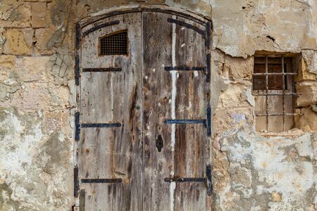 Texture of an old wooden wooden door with unusual metal handles on the island of Maltaの写真素材
