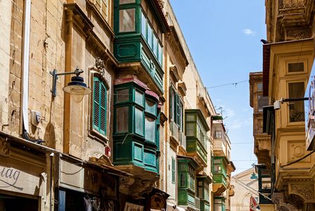 Architecture of Malta, the facade of the house with colorful wooden windows and a balcony on the island of Maltaの写真素材
