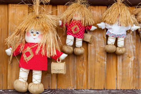 Three textile dolls in red and white T-shirts with small wooden boxes.の写真素材