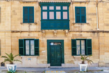 Malta architecture, facade of a house with wooden windows and a green balcony on the island of Maltaの写真素材