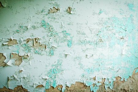 An abstract background of the old wall in blue color. The texture covered with cracks from paint.