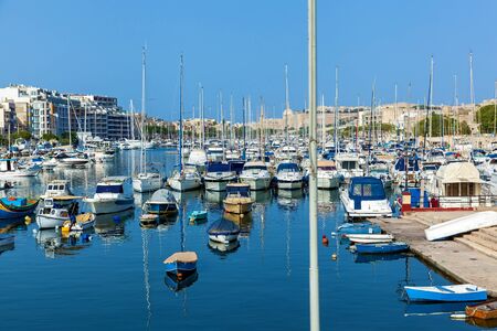A panorama of the marine city with different types of boats that moored at the port on a sunny day.の写真素材