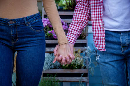 Young beautiful couple in love in a good mood walks in the autumn park, holding hands. Young couple...
