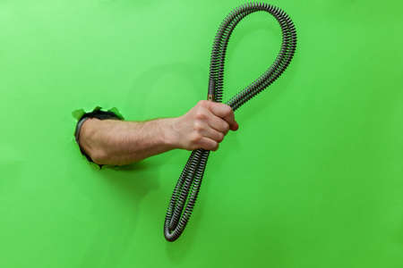 A man holds a wastewater treatment tool with various nozzles on a green background