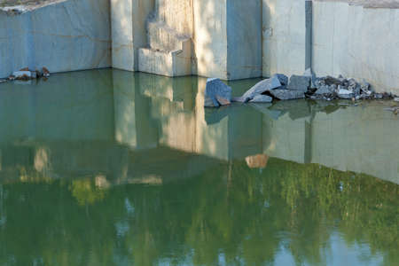 Granite quarry with large granite blocks Abandoned granite quarry with rain water. Granite mining in...