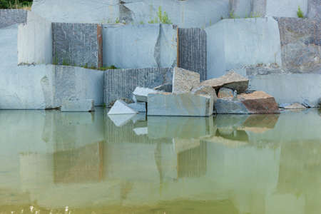 Granite quarry with large granite blocks Abandoned granite quarry with rain water. Granite mining in...