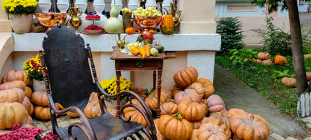 Autumn outdoor composition with rocking chair, flowers and pumpkinsの写真素材