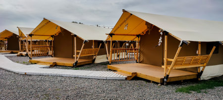 Large wooden framed tents with wooden walkways in a campgroundの写真素材