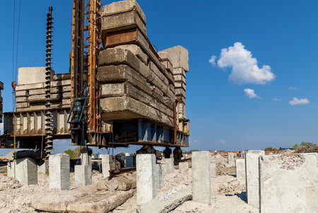 Equipment for installing concrete piles on construction sites. Hammered concrete piles sticking out of the ground at a construction siteの写真素材