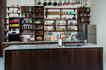 Working area of the kitchen. Kitchen cabinet with jars, cups, spices, plates, kitchen countertop...
