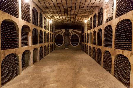 Old wine cellar with stacks of old wine bottles.Old wine bottles are stacked in rows in the cellars of the wineryの写真素材
