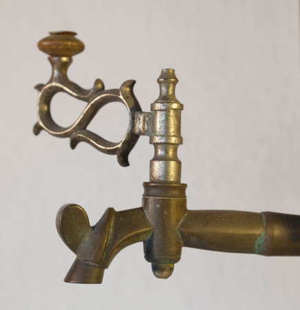 Old brass faucet of antique samovar on background white wall.の写真素材