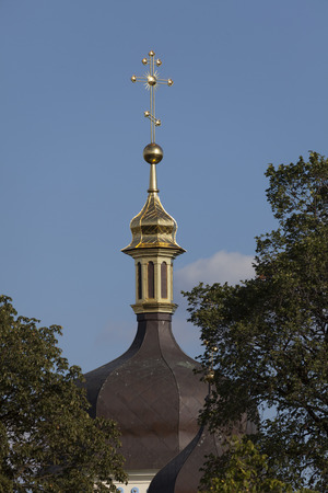 Golden Cross Orthodox church in the sun on a blue sky background.の写真素材
