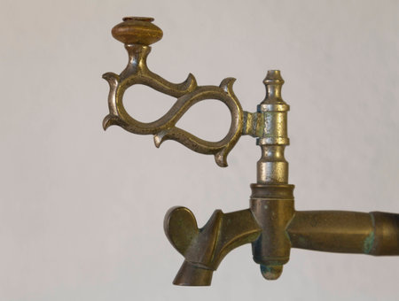 Old brass faucet of antique samovar on background white wall.の写真素材
